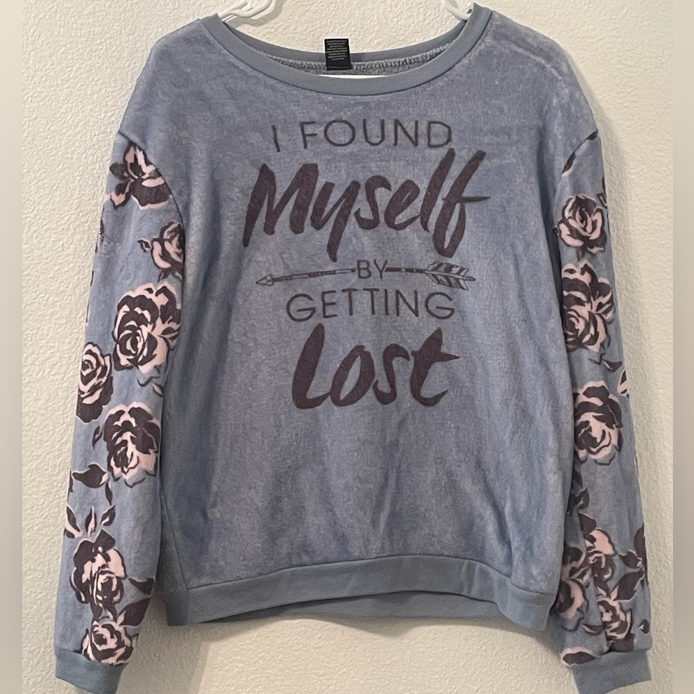 A soft and fluffy sweatshirt with “I found myself by getting lost” on the front